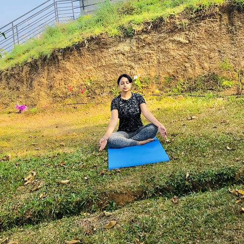 Seated meditation on a mat on grass, outdoors
