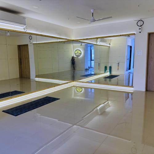 The mirrored wall of the Baner studio with mats laid out